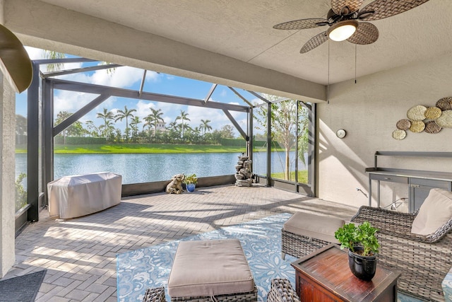 view of patio / terrace featuring grilling area, a lanai, a water view, and ceiling fan