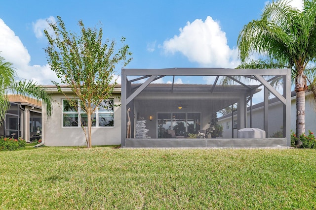 back of house with a lawn and glass enclosure