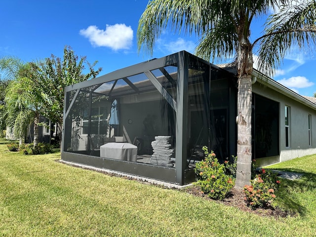 view of property exterior with a lawn and glass enclosure