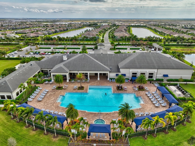 view of swimming pool featuring a patio and a water view