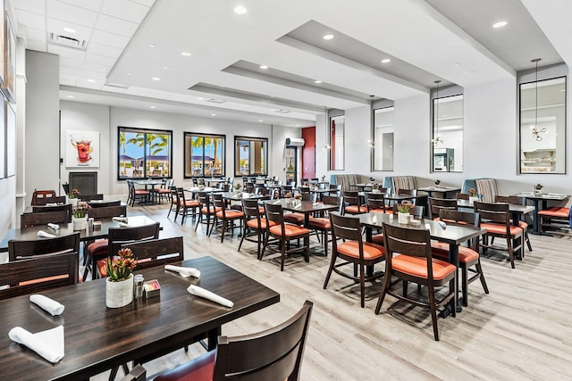 dining area featuring light hardwood / wood-style floors and a raised ceiling