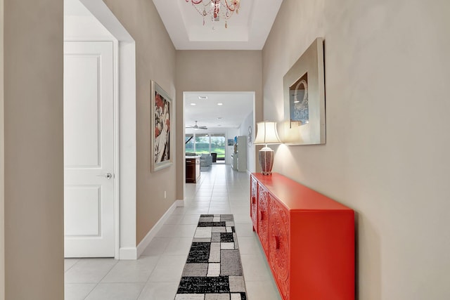 hall featuring light tile patterned floors and a chandelier