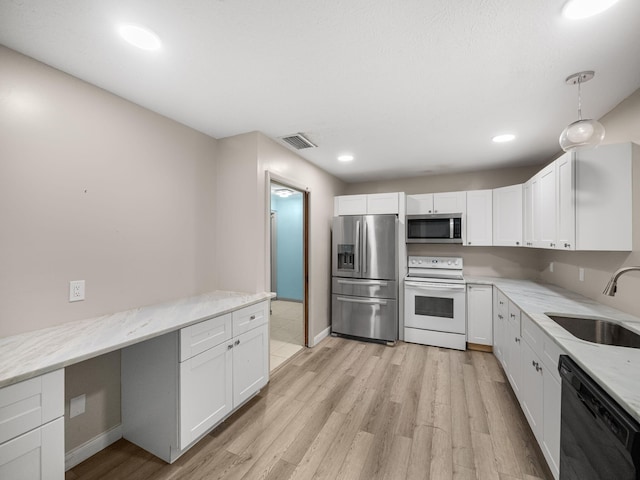 kitchen with stainless steel appliances, sink, white cabinetry, and light hardwood / wood-style flooring