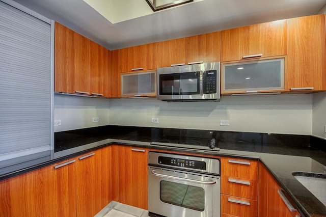 kitchen featuring appliances with stainless steel finishes, brown cabinets, and modern cabinets