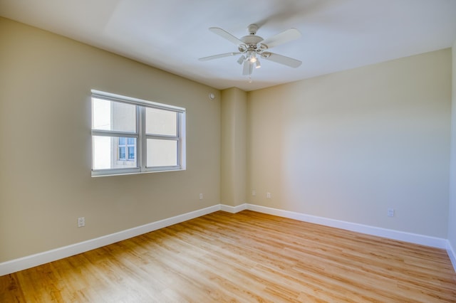 unfurnished room with light wood-style floors, ceiling fan, and baseboards