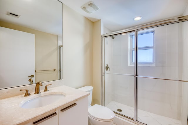 full bathroom featuring toilet, a stall shower, vanity, and visible vents