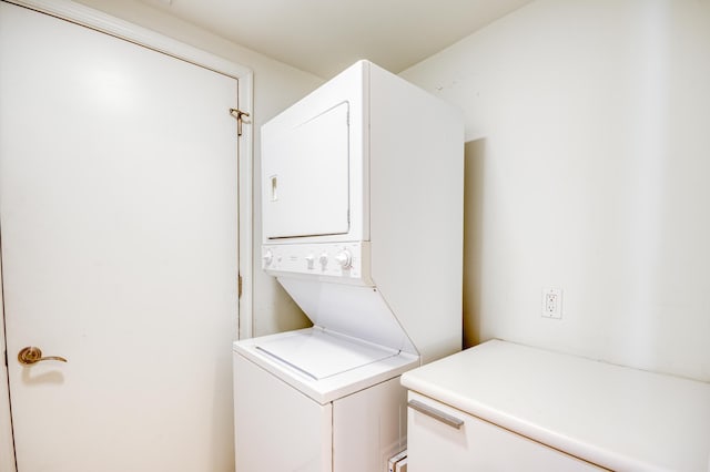 clothes washing area with stacked washer / dryer