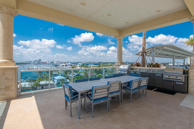 view of patio with outdoor dining space, area for grilling, and a view of city