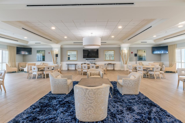 living room with a raised ceiling, wood finished floors, and recessed lighting