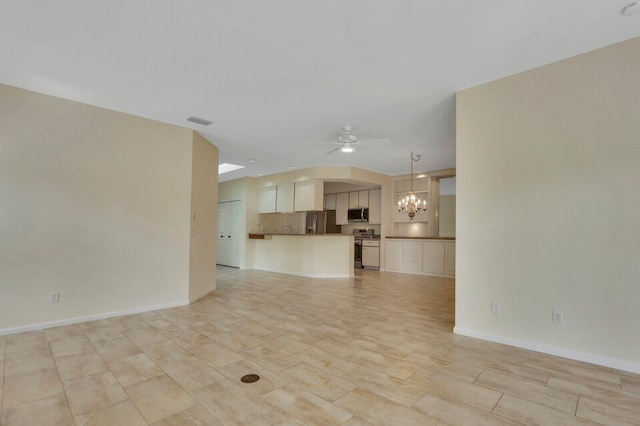 unfurnished living room with ceiling fan with notable chandelier