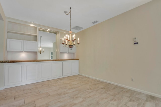 unfurnished dining area with an inviting chandelier