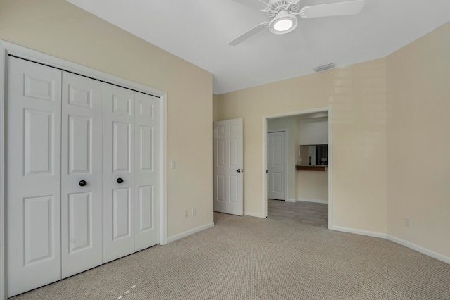 unfurnished bedroom with a closet, ceiling fan, and light colored carpet