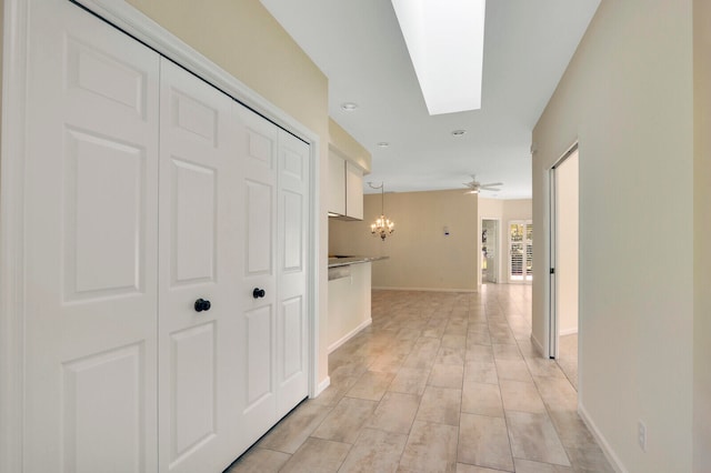 hall with an inviting chandelier and a skylight