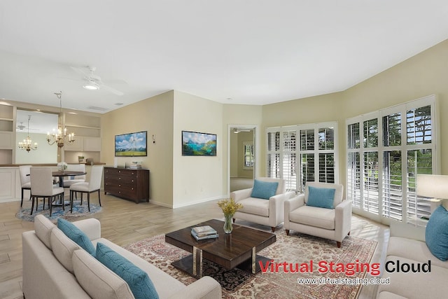 living room featuring ceiling fan with notable chandelier and light hardwood / wood-style floors