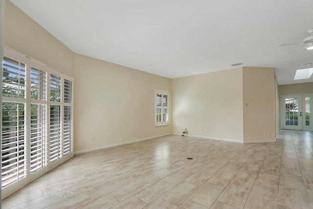 empty room with a skylight, plenty of natural light, and ceiling fan