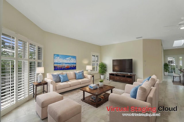 living room with a skylight, ceiling fan, plenty of natural light, and light tile patterned flooring