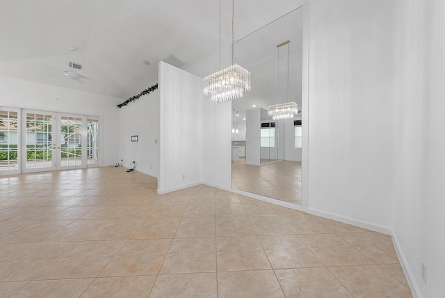 empty room with light tile patterned flooring, ceiling fan with notable chandelier, and lofted ceiling