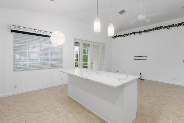 kitchen with light tile patterned floors, lofted ceiling, ceiling fan, french doors, and decorative light fixtures