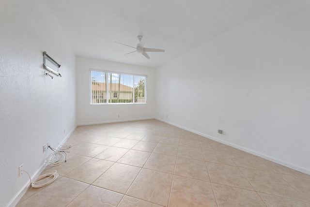 tiled spare room featuring ceiling fan