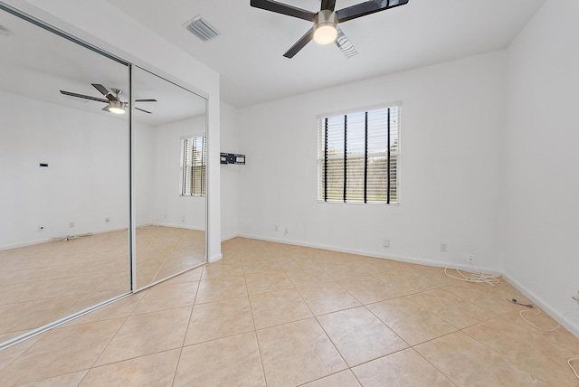 unfurnished bedroom featuring a closet, ceiling fan, and light tile patterned floors