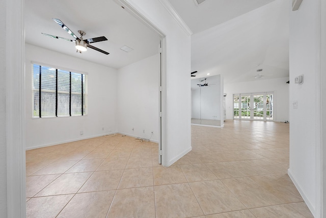 tiled spare room featuring ornamental molding, lofted ceiling, ceiling fan, and plenty of natural light