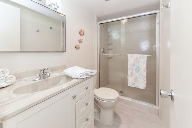 bathroom featuring toilet, vanity, hardwood / wood-style floors, and walk in shower