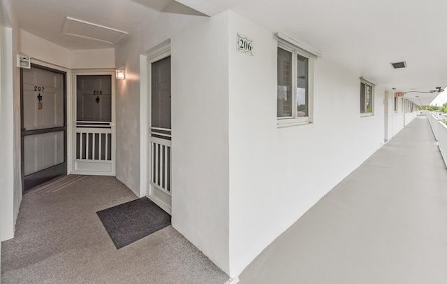 hall featuring light colored carpet