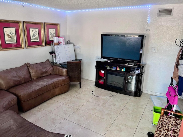 living room with a textured ceiling and light tile patterned floors