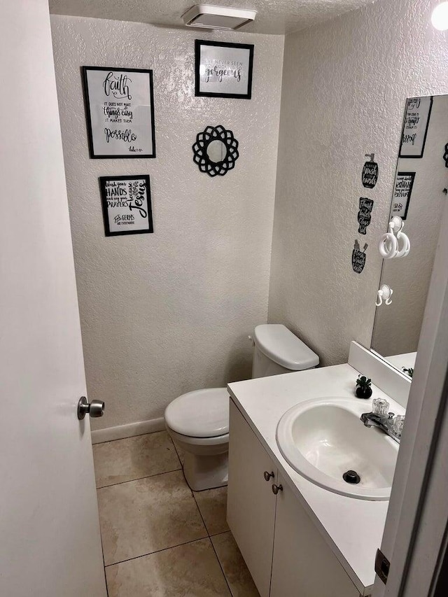 bathroom with vanity, tile patterned flooring, and toilet