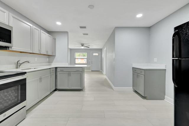 kitchen with gray cabinetry, sink, stainless steel appliances, and kitchen peninsula