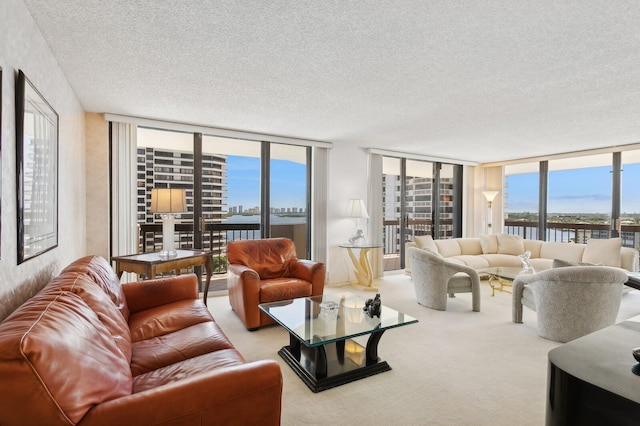 living room with expansive windows, a water view, light colored carpet, and a textured ceiling