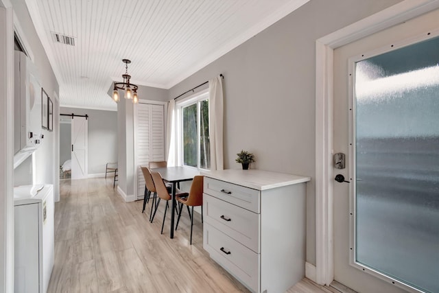 dining room with ornamental molding, light wood-type flooring, a barn door, and wood ceiling