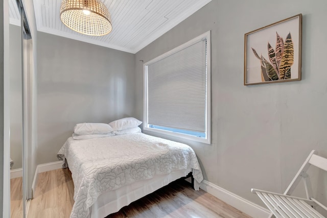 bedroom featuring wooden ceiling, ornamental molding, and hardwood / wood-style flooring