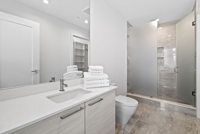 bathroom with recessed lighting, a shower stall, toilet, and vanity