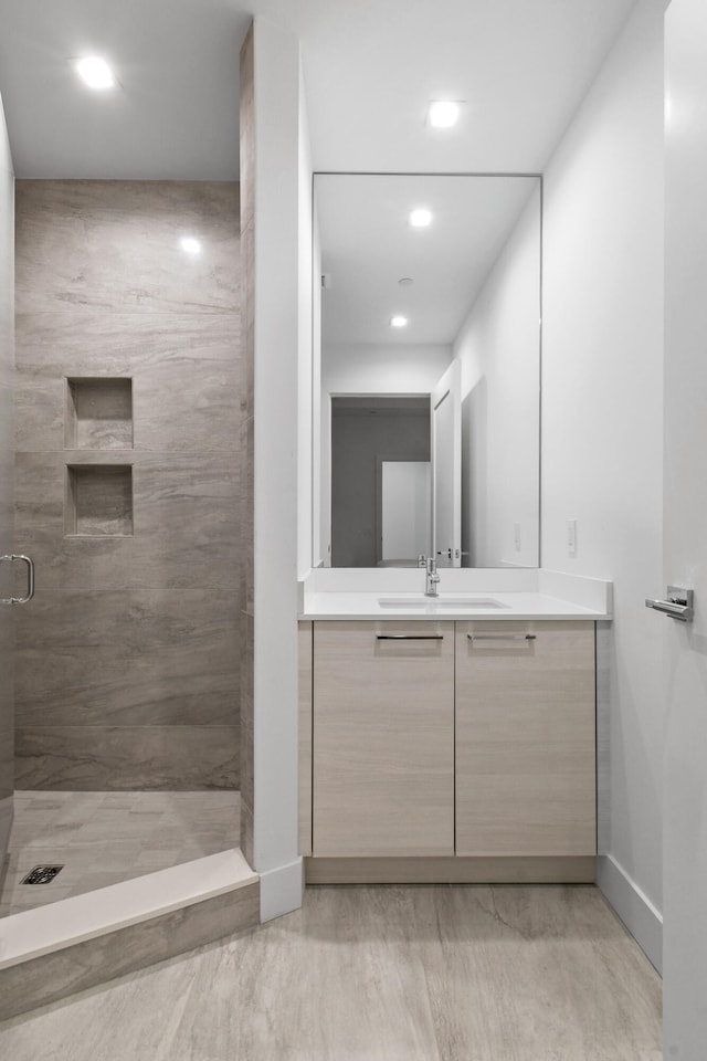 bathroom with vanity and a tile shower