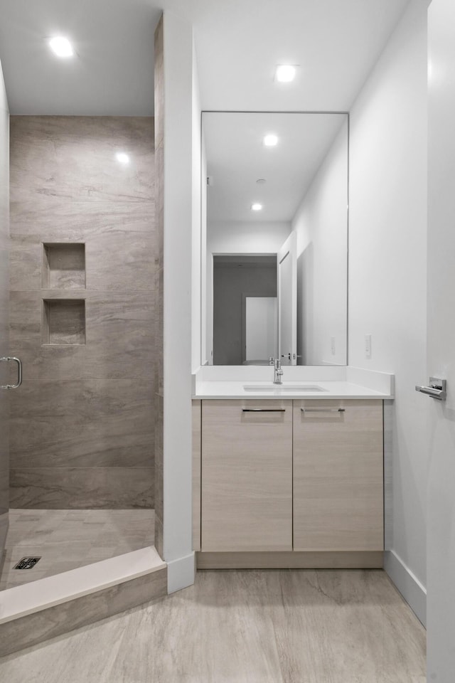 bathroom with vanity, baseboards, a stall shower, and recessed lighting