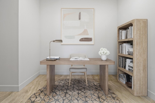 office space featuring baseboards and wood finished floors