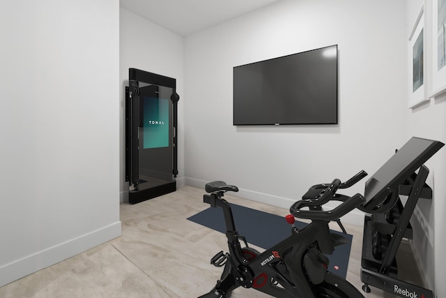 exercise room with baseboards and carpet flooring