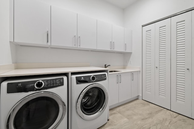 laundry room with washing machine and clothes dryer and cabinet space