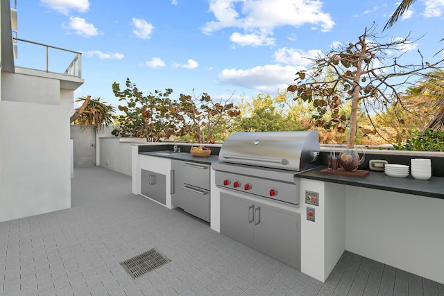view of patio with visible vents, a balcony, a sink, and area for grilling