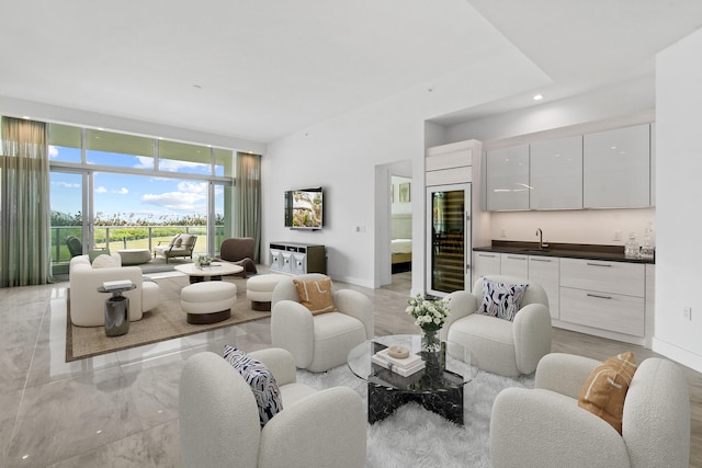 living room featuring floor to ceiling windows, sink, and wine cooler