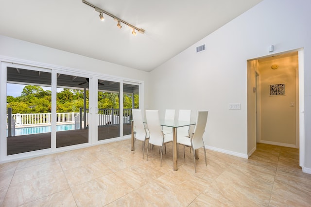 1121 SW Pine Tree Ln, Palm City, FL 34990 - dining room featuring track lighting, high vaulted ceiling, and baseboards