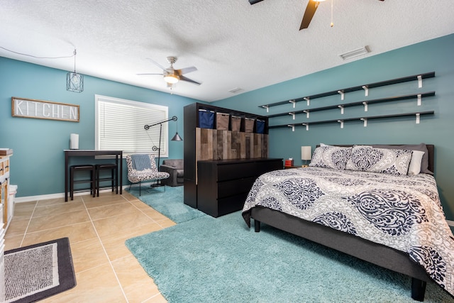 1121 SW Pine Tree Ln, Palm City, FL 34990 - tiled bedroom featuring ceiling fan, baseboards, and a textured ceiling