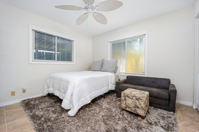 1121 SW Pine Tree Ln, Palm City, FL 34990 - bedroom with baseboards, tile patterned floors, and a ceiling fan