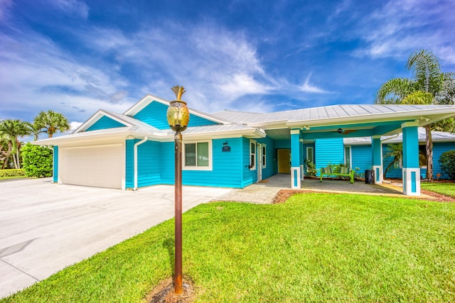 1121 SW Pine Tree Ln, Palm City, FL 34990 - single story home with an attached garage, ceiling fan, a front yard, metal roof, and driveway