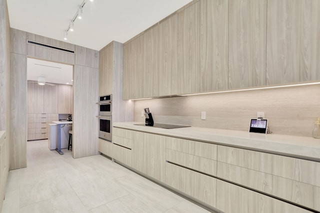 kitchen featuring light tile patterned flooring, stainless steel double oven, black electric cooktop, light brown cabinets, and tile walls