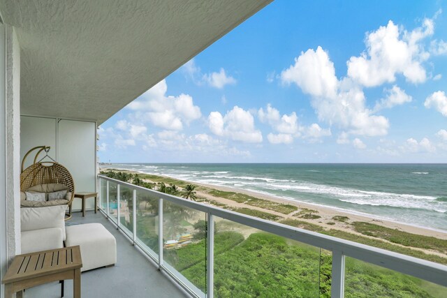 balcony featuring a beach view and a water view