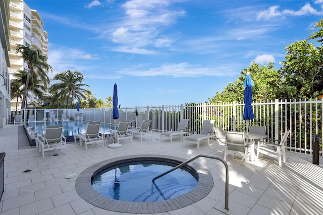 view of pool featuring a patio and a hot tub