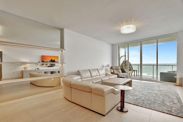 living room featuring a water view, expansive windows, and a notable chandelier