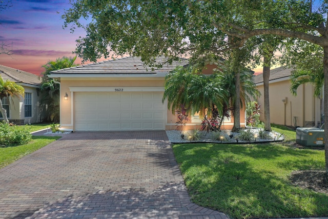 view of front of home with a lawn and a garage